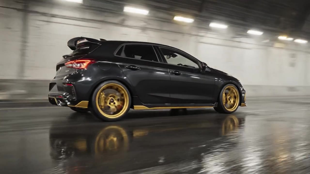 Elegante hatchback ad alte prestazioni mostrato in movimento dinamico attraverso un tunnel nebbioso, che evidenzia ruote di lusso ed estetica di design sportivo