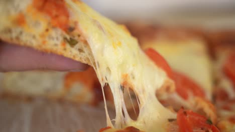 Hand-Picks-up-Slice-of-Pizza,-Cheese-Stretching,-Slow-Motion-Side-View