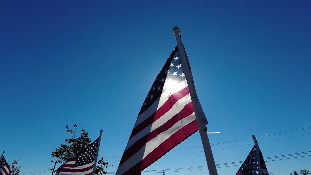 Bandiera americana con il sole alle spalle e cieli azzurri