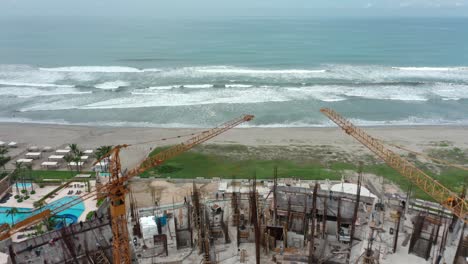 disparo de drones sobre un edificio en progreso con vista al mar en el día, gran angular