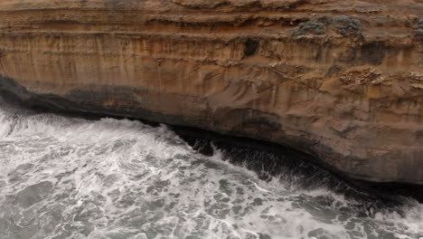 ocean waves crashing against rock face. aerial views