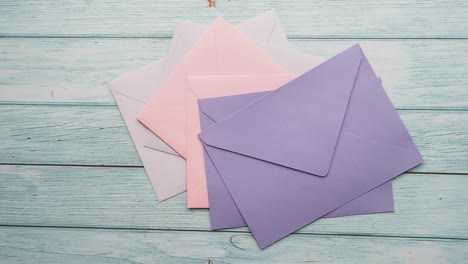 pastel colored envelopes on wooden background