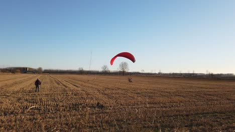 paragliding that takes off from agricultural fields and rises to the sky in backlight