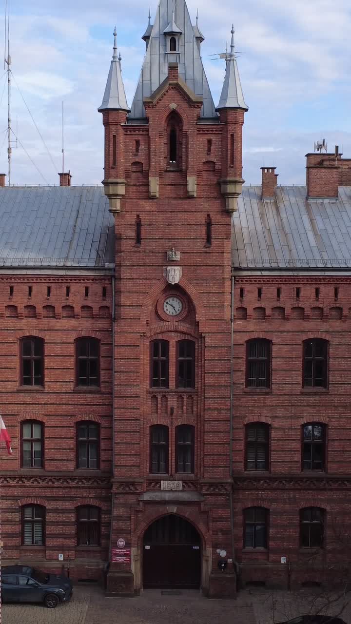 Vista Aérea de Edifício Histórico de Tijolos Vermelhos com Torre do Relógio.