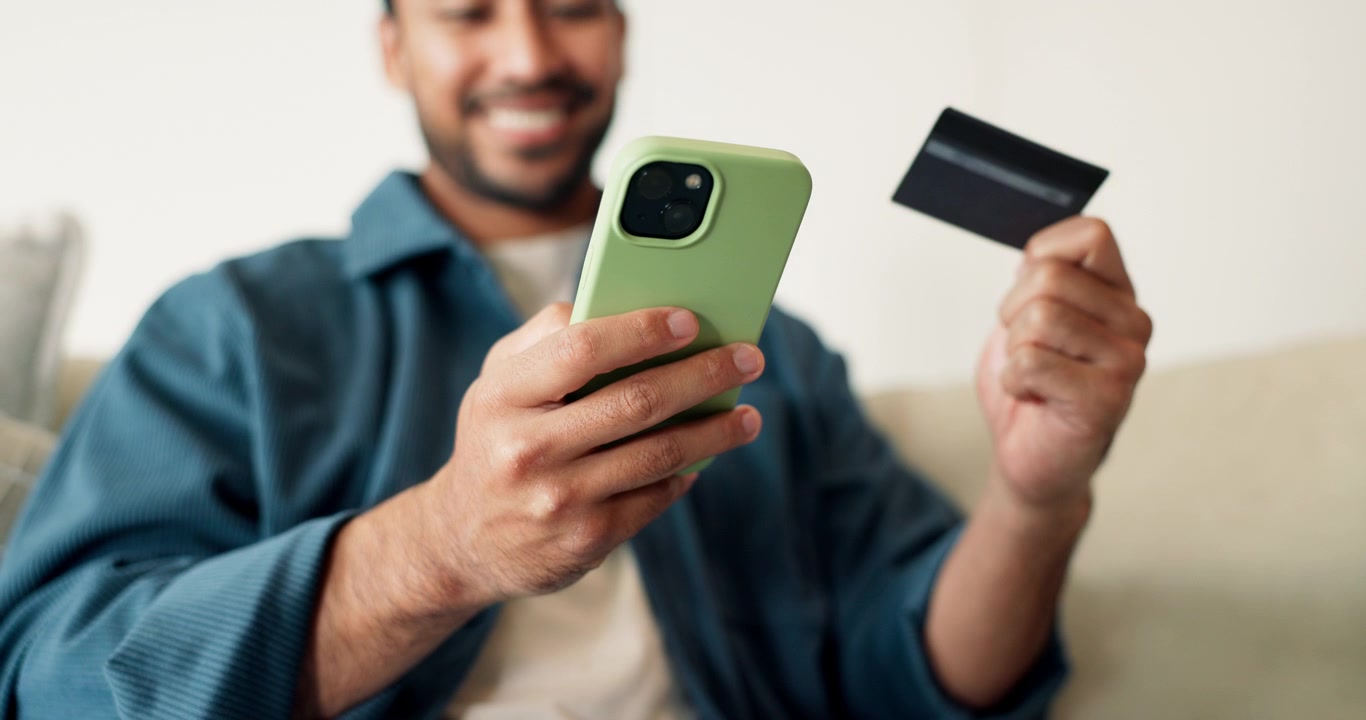 Man Shopping Online Using Smartphone and Credit Card