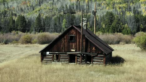 dolly zoom of cabin in field with mountains in background