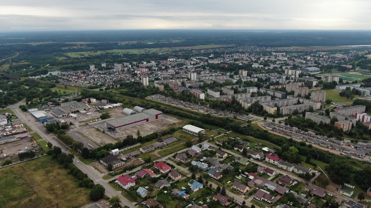 Private houses and block apartment building in distance, aerial drone view