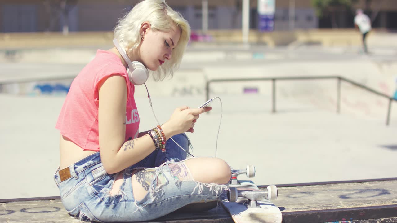 Trendy young blond woman at a skate park
