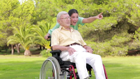 nurse walking an old man in wheelchair