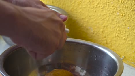 manos masculinas recogiendo patatas de boal de plata y pelándolas con un pelador de cerca