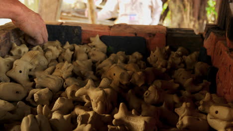 manos hábiles apilan flautas de animales de arcilla artesanales en thanh ha, vietnam, una encantadora atracción turística que muestra el arte tradicional