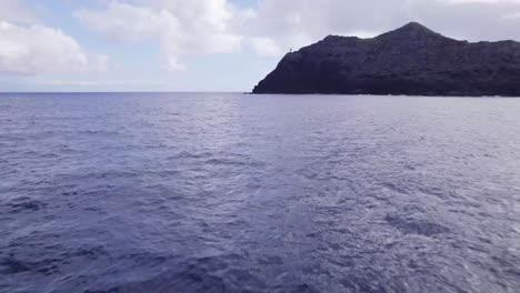 Un-Dron-Cruzó-Volando-Bajo-A-Través-Del-Océano-Pacífico-Acercándose-A-Los-Acantilados-Rocosos-De-La-Isla-Kaohikaipu-Frente-A-La-Costa-De-Oahu,-Hawaii.