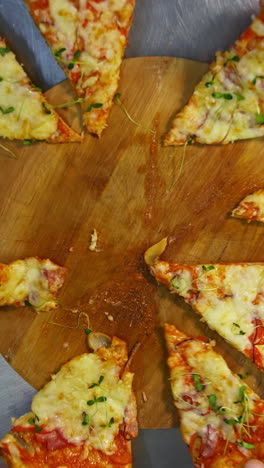 hands are taking pizza portions. ready pizza on the table. people take slices of delicious pizza in pizzeria. top view. vertical video