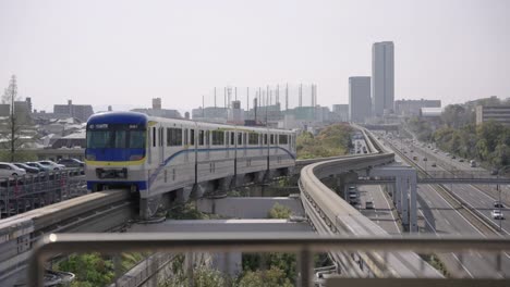 Osaka-Monorail-departing-Yamada-Station-on-clear-afternoon,-Japan-4k