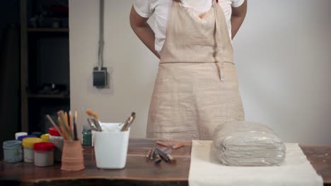 woman tying an apron in a pottery studio