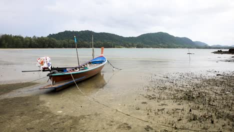 longtail boat tied up along the beach in koh lanta, thailand