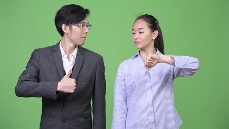 young asian business couple having different decisions together