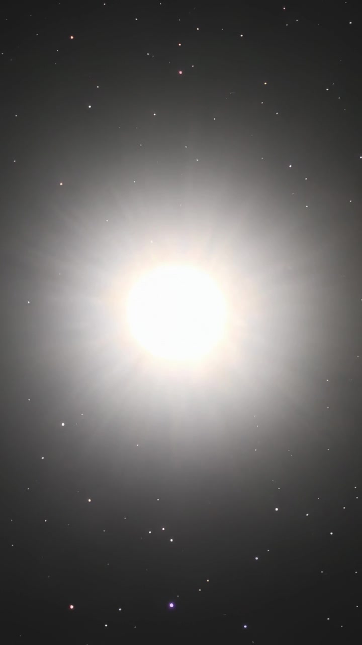Vídeo vertical: Mostrando disco lunar brilhante formando halo anelado à noite, com câmera ajustando o foco