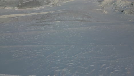 aerial view in the swiss alps, skiers and snowboarders waiting on top of a ski slope