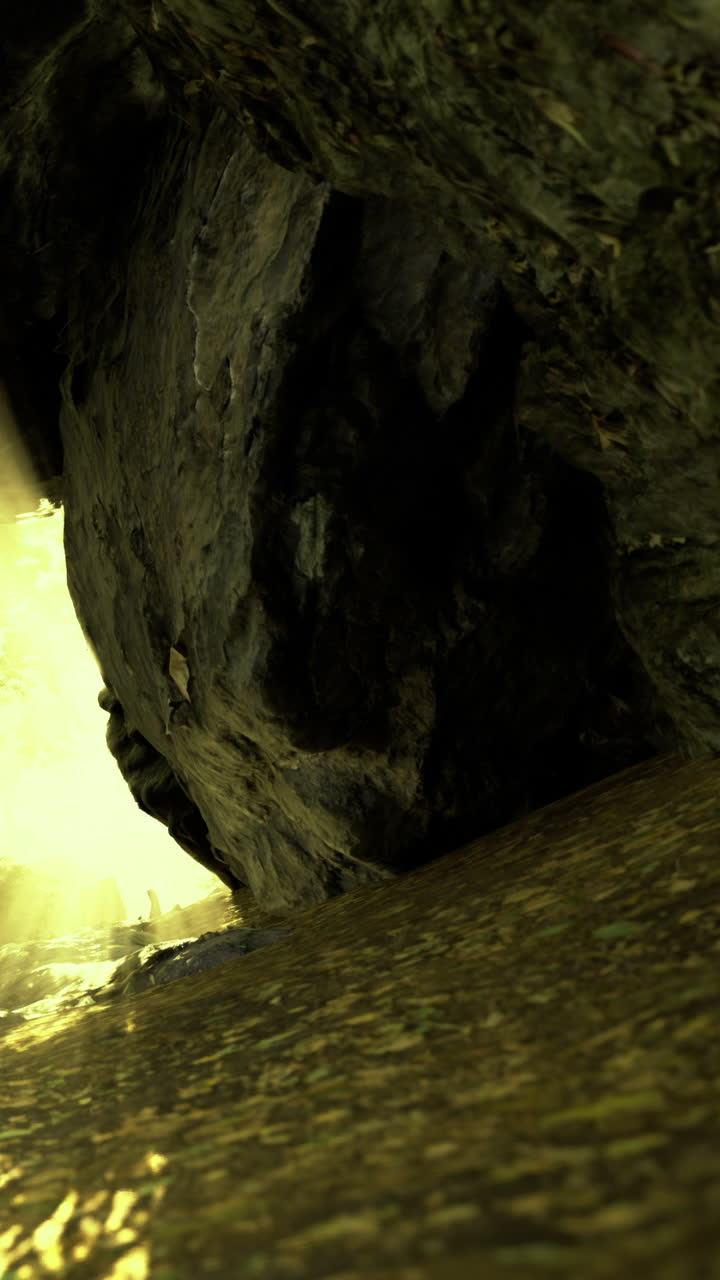 La luce del sole filtra attraverso un'apertura rocciosa per rivelare sabbia dorata scintillante.