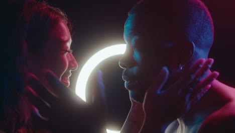 young romantic couple kissing under neon lights