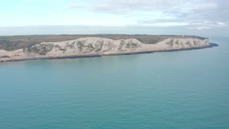 Aerial-drone-shot-towards-the-white-cliffs-of-dover-over-the-sea