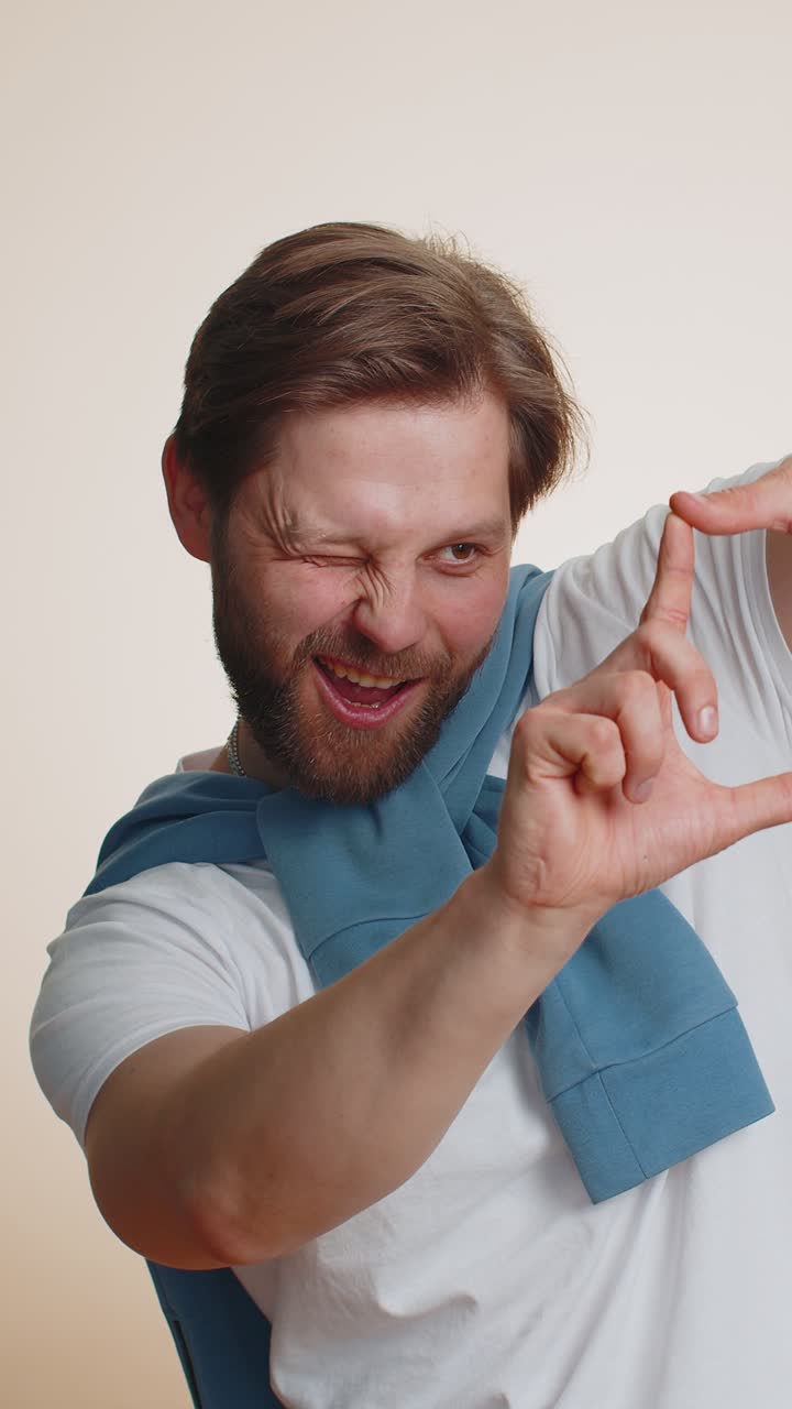 Manlig fotograf som gör bildram med händerna och fokuserar på intressant ögonblick som beskär fin bild