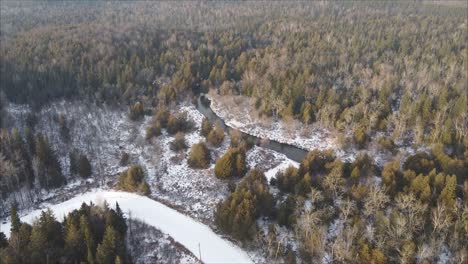 Drohnenaufnahme-Der-Straße,-Umgeben-Von-Nadelwald-Im-Winter,-Neuschnee-Und-Bach