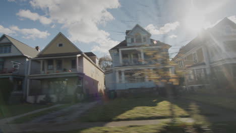 drive along the street with typical us houses, behind them beautifully illuminated by the sun