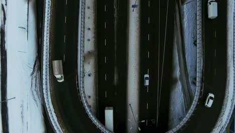 Top-view-of-car-traffic-on-snowy-highway-intersection