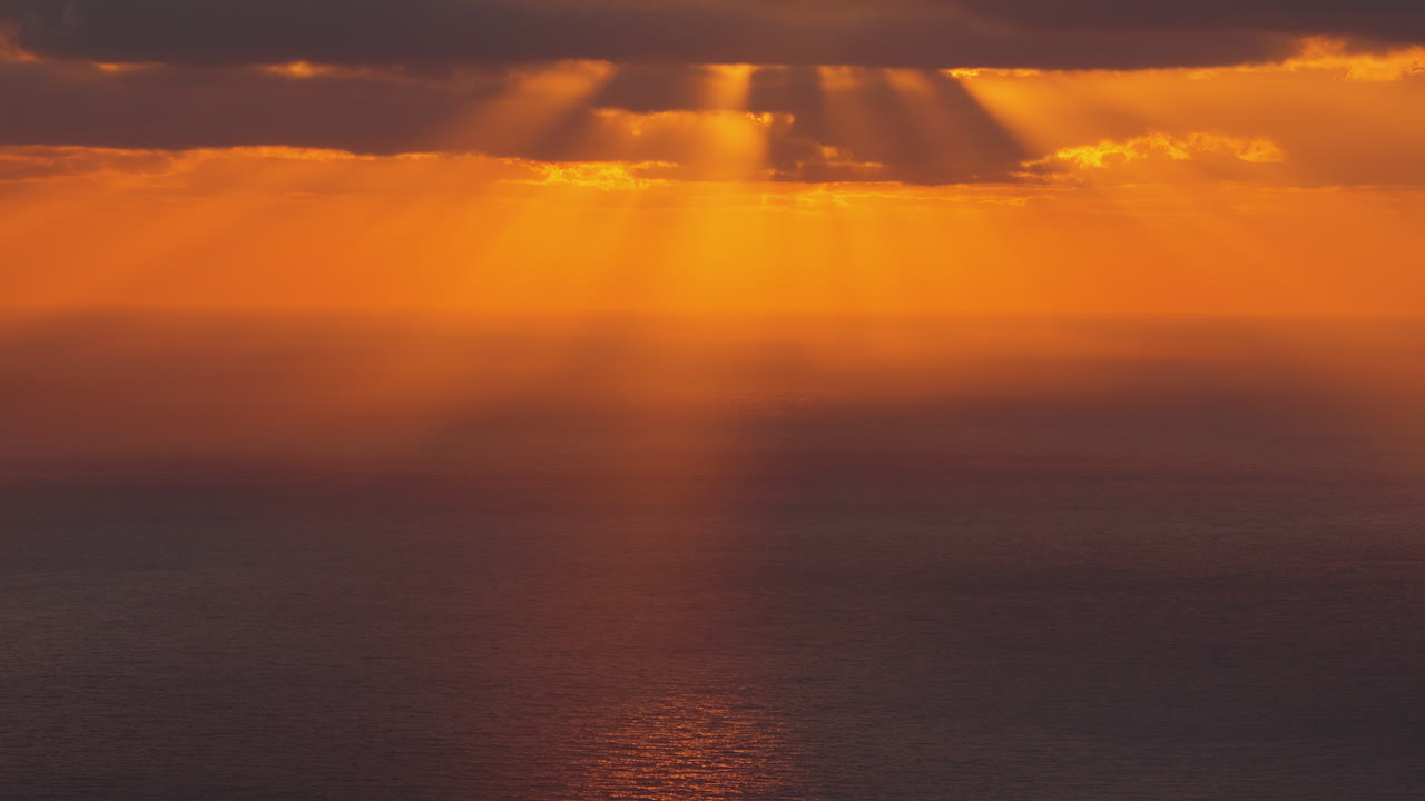 Droneutsikt over en gyllen solnedgang som reflekteres på det rolige Middelhavet.