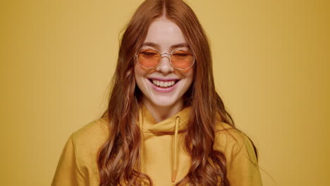 charming girl smiling in studio. woman posing at lens on orange background