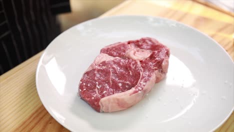 raw steak on a plate ready to be cooked