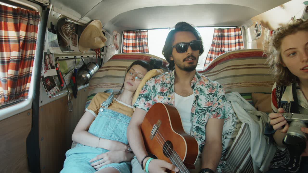 도로 여행 중 밴 에서 기타 를 연주 하고 사진 을 찍는 친구 들