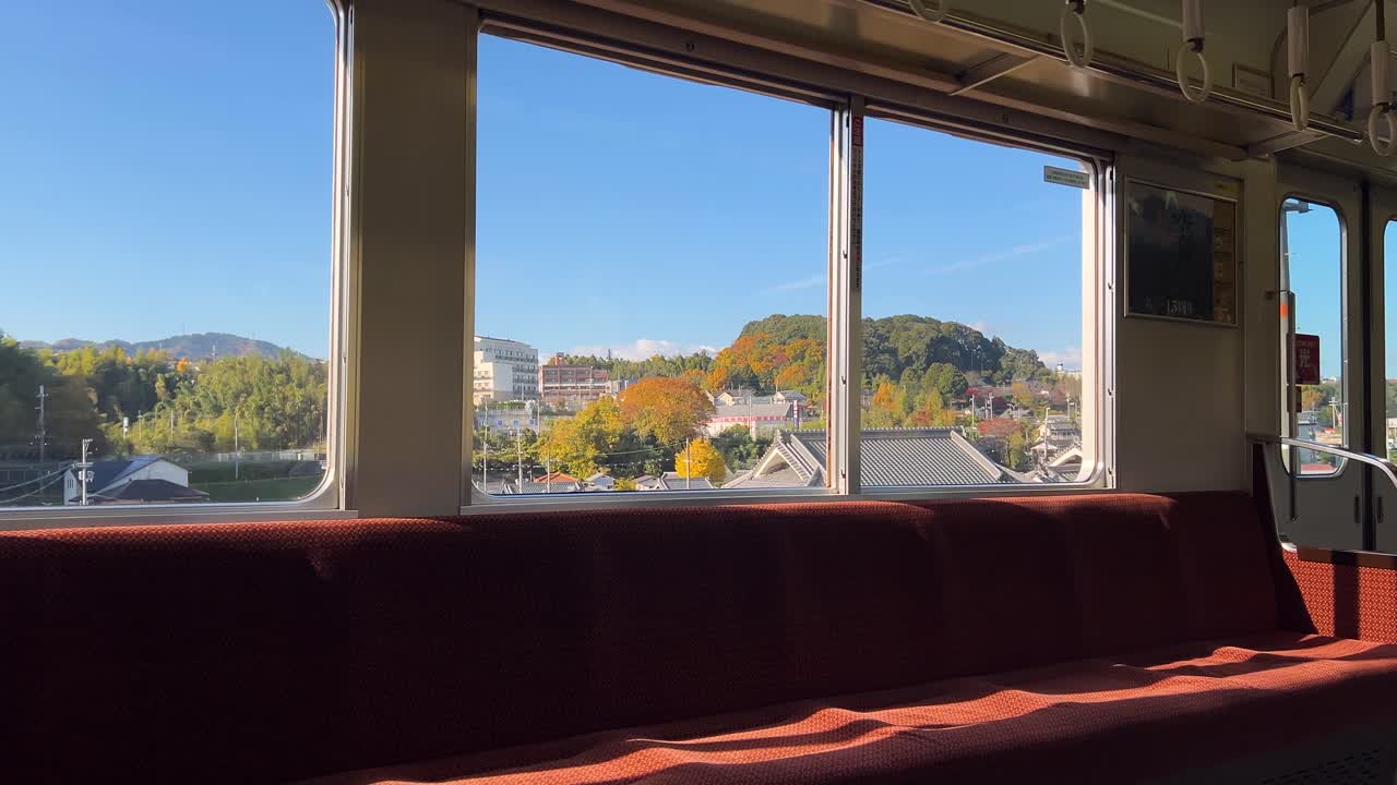 Interior view of Japanese local train running through rural countryside in Fall