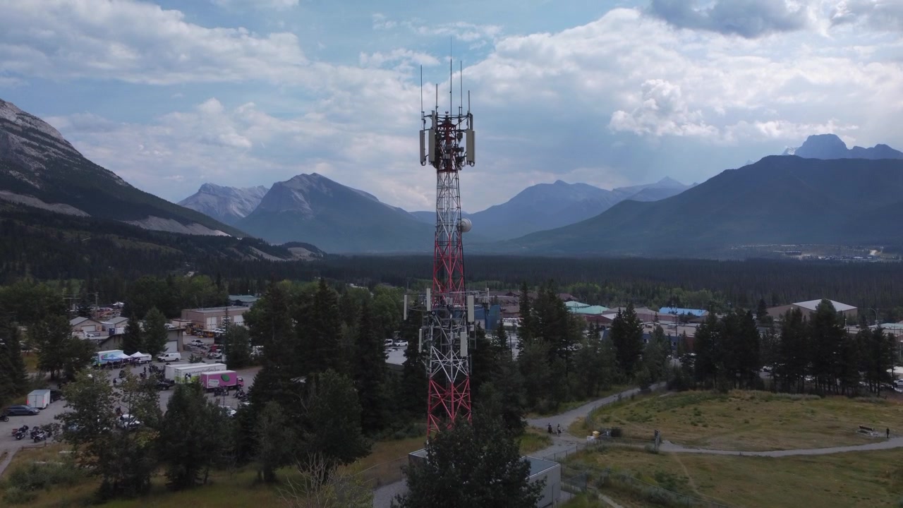 Torre di telefonia mobile in un paese di montagna, avvicinamento lento, riprese aeree con drone.