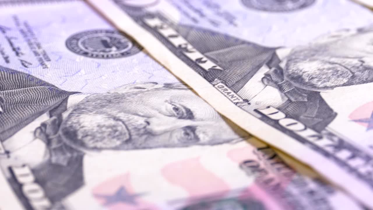 Lenta rotazione di banconote americane da cinquanta dollari. Sfondo con denaro