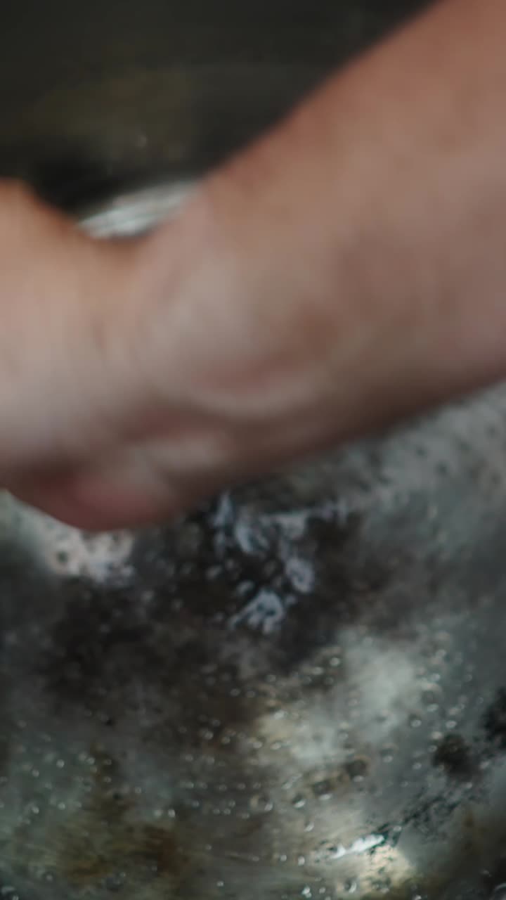Cleaning a pot with a hand