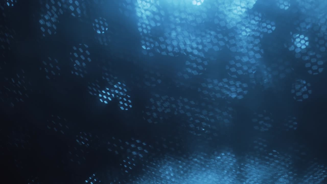 Blue abstract optical blurred background. Optical bokeh overlapped by moving honeycombs.