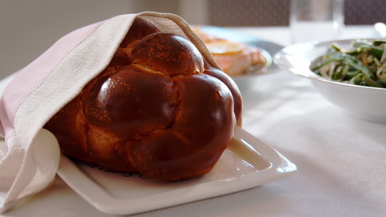 Challah bread on a table set for Jewish Shabbat, close up