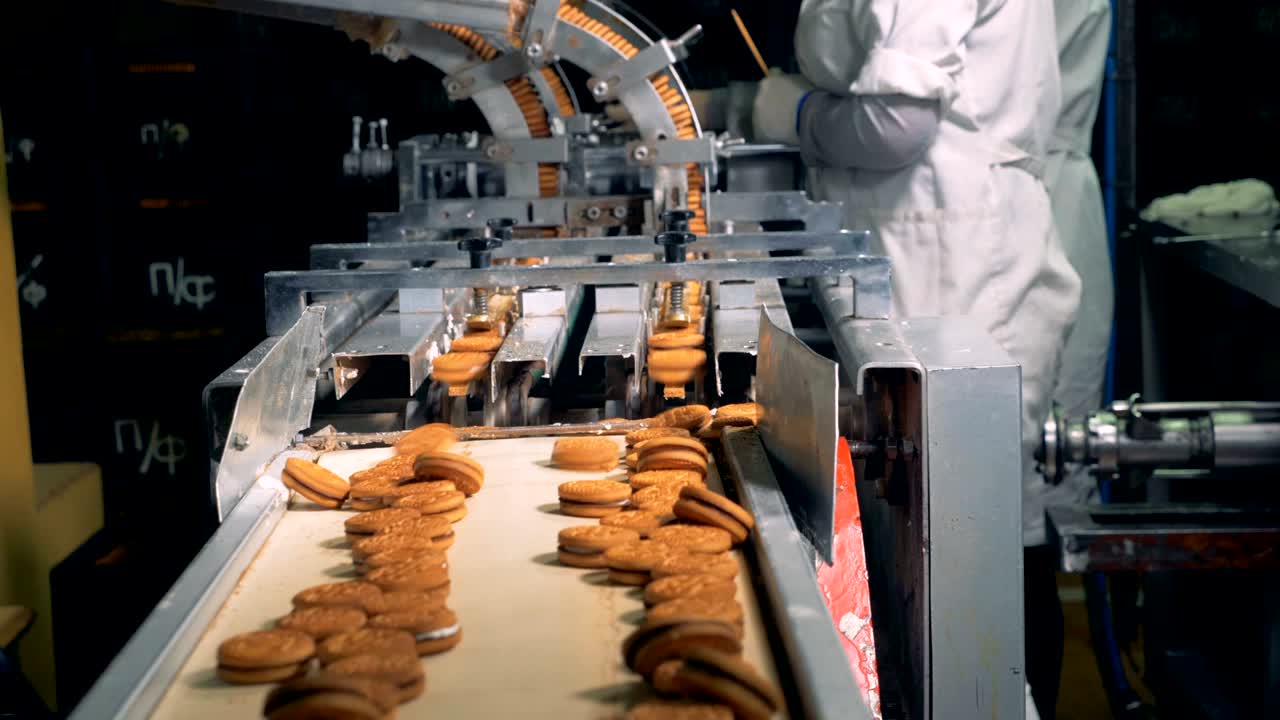 las galletas listas se mueven a lo largo de la correa después de caer del transportador