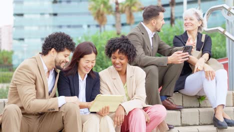 diverse business team collaborating outdoors using a tablet