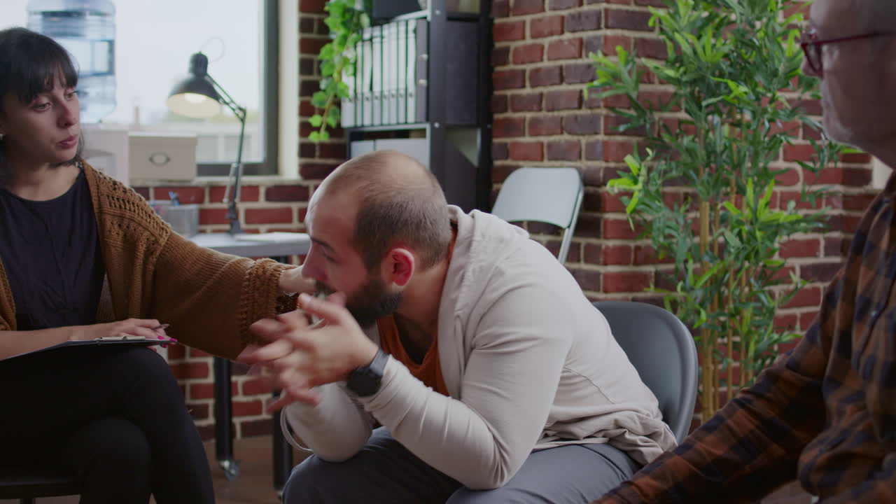 Alcohol addict sharing anger management issues with people at aa rehab meeting