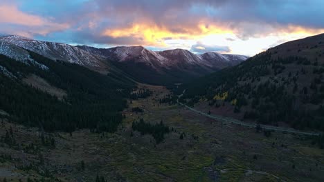 drone footage capturing the golden glow of the setting sun over a mountain valley in independence pass