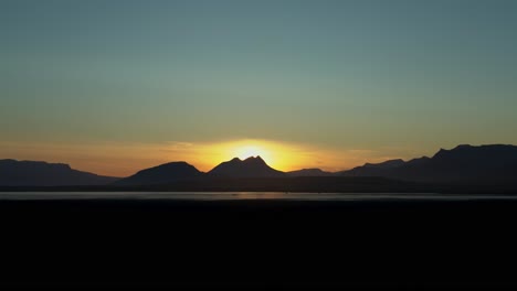 Panorama-shot-showing-black-silhouette-of-massive-volcanoes-and-epic-sunset-in-background-on-Iceland-Island