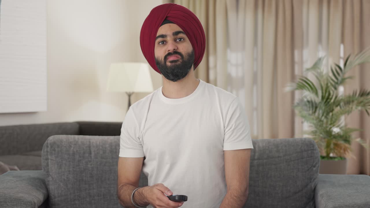 hombre indio sikh enojado viendo la televisión