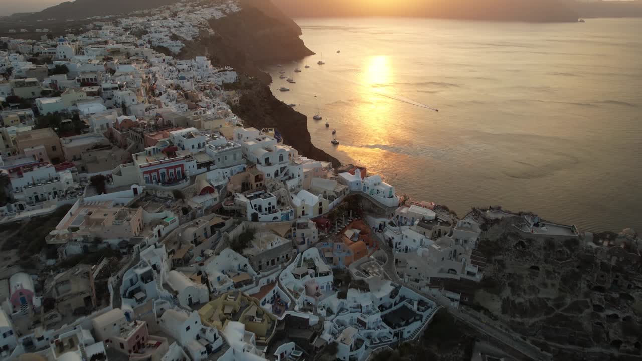puesta de sol sobre la isla de santorini y el mar egeo, vista aérea del pueblo y la costa de oia