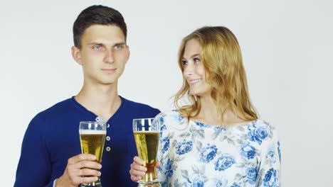 hombre y mujer con vasos de cerveza en un video hd de fondo blanco