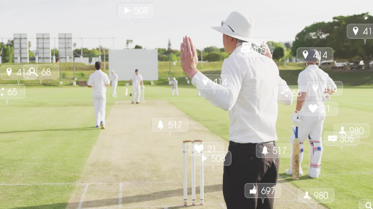 Cricket umpire raising hand on cricket pitch for technology demo, with social media icons floating