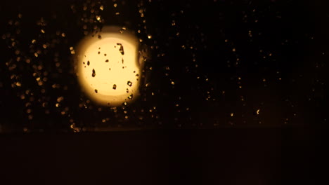 luna borrosa fuera de la ventana lluviosa